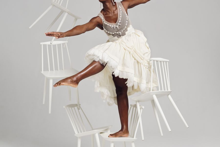 Lashana Lynch Dancing Among Floating Chairs