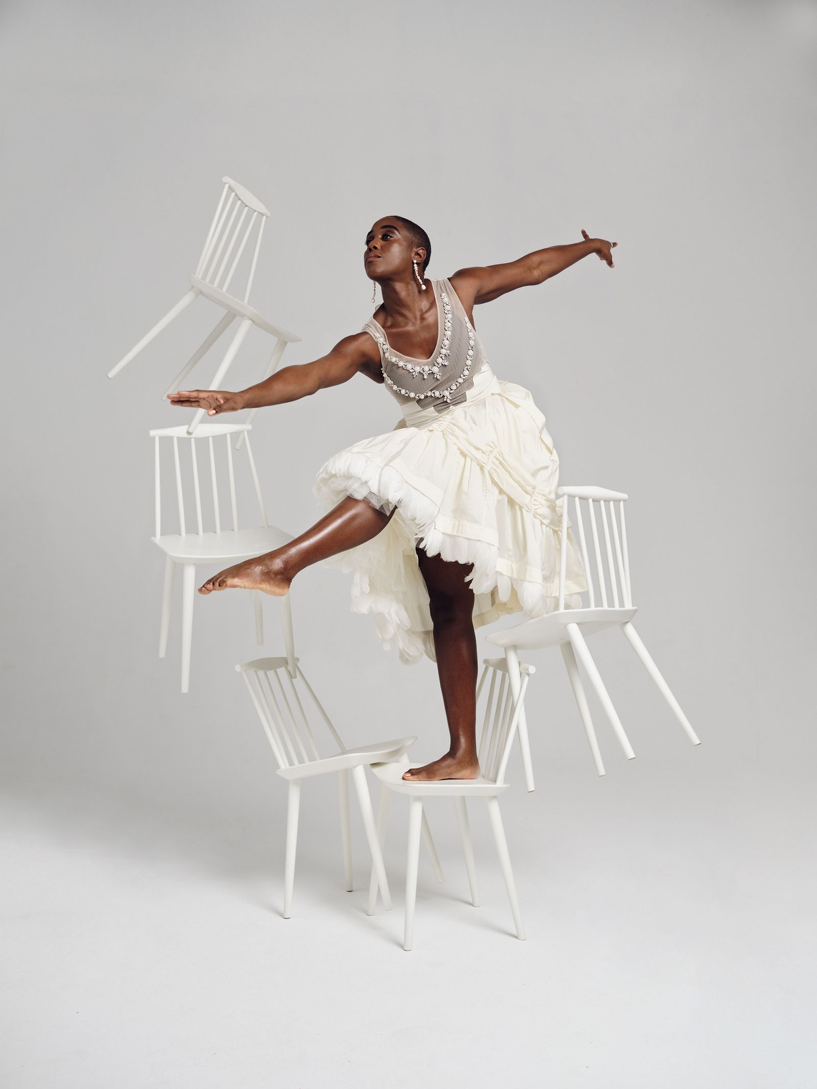 Lashana Lynch Dancing Among Floating Chairs